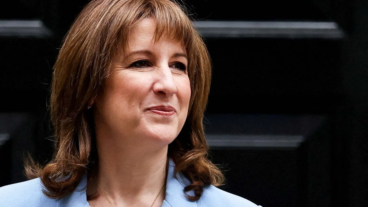 Reuters Rachel Reeves smiling in front of black Downing Street door